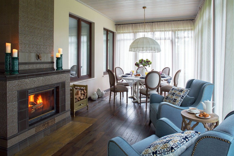 Design ideas for a mid-sized traditional sunroom with a standard fireplace, a tile fireplace surround and brown floor.