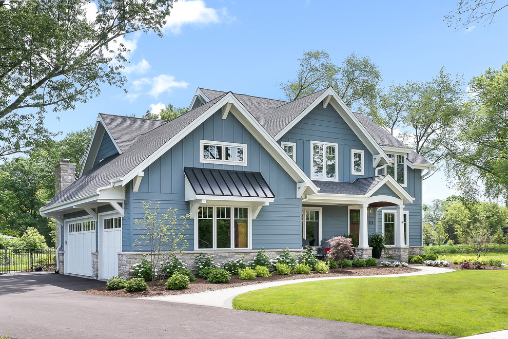 This is an example of a large arts and crafts two-storey blue house exterior in Chicago with a gable roof, a shingle roof and wood siding.