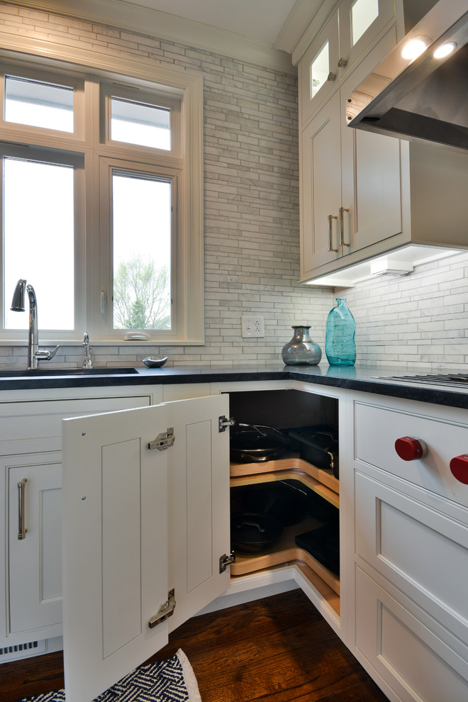 Inspiration for a large transitional u-shaped dark wood floor and brown floor eat-in kitchen remodel in Chicago with an undermount sink, recessed-panel cabinets, white cabinets, soapstone countertops, gray backsplash, marble backsplash, stainless steel appliances and an island