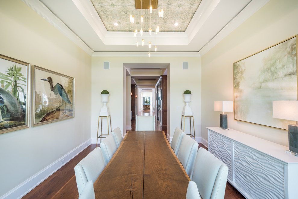 This is an example of a beach style separate dining room in Miami with beige walls, medium hardwood floors and brown floor.