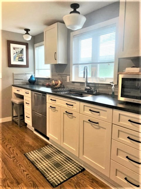 Mid-sized transitional enclosed kitchen photo in Seattle with shaker cabinets, white cabinets and black countertops