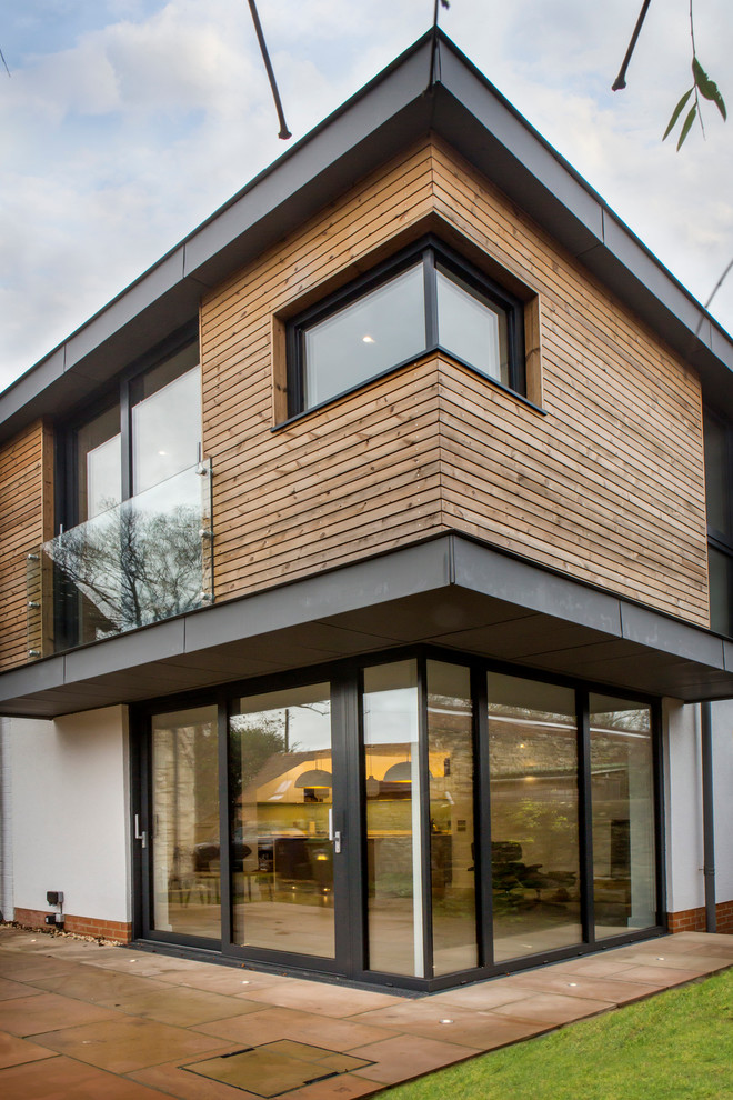 This is an example of a contemporary two-storey white exterior in Oxfordshire with wood siding.