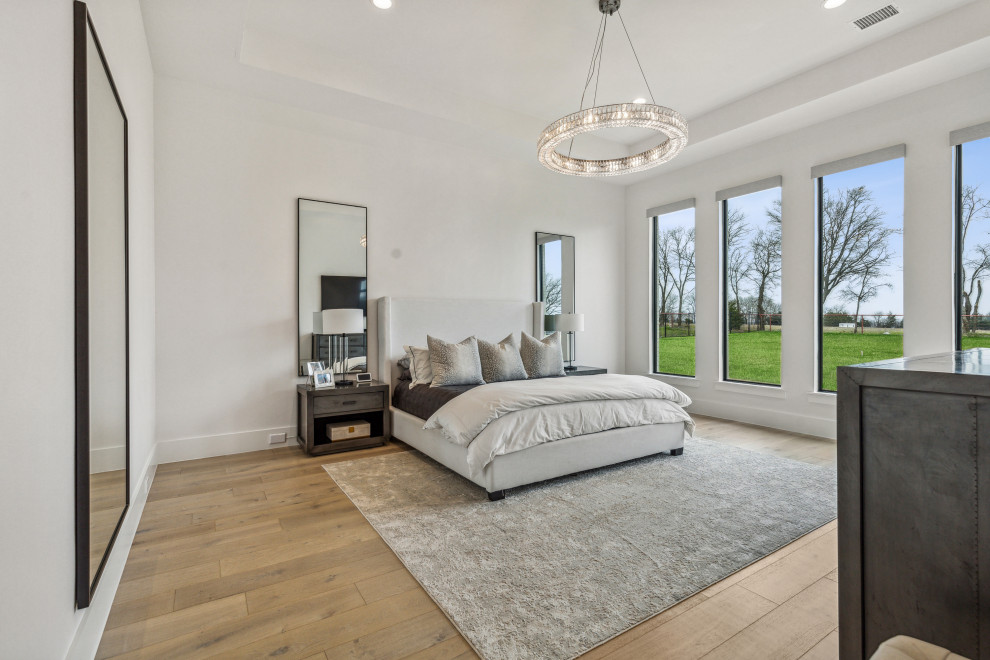 Diseño de dormitorio principal actual grande con paredes blancas, suelo de madera clara, suelo blanco y bandeja