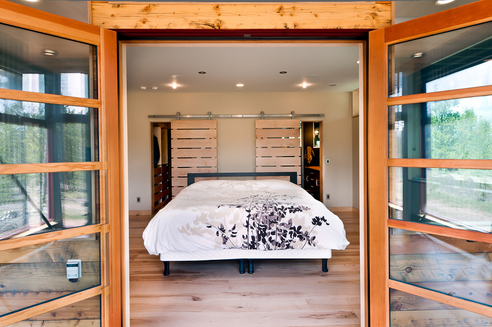 Design ideas for a contemporary bedroom in Denver with white walls and light hardwood floors.