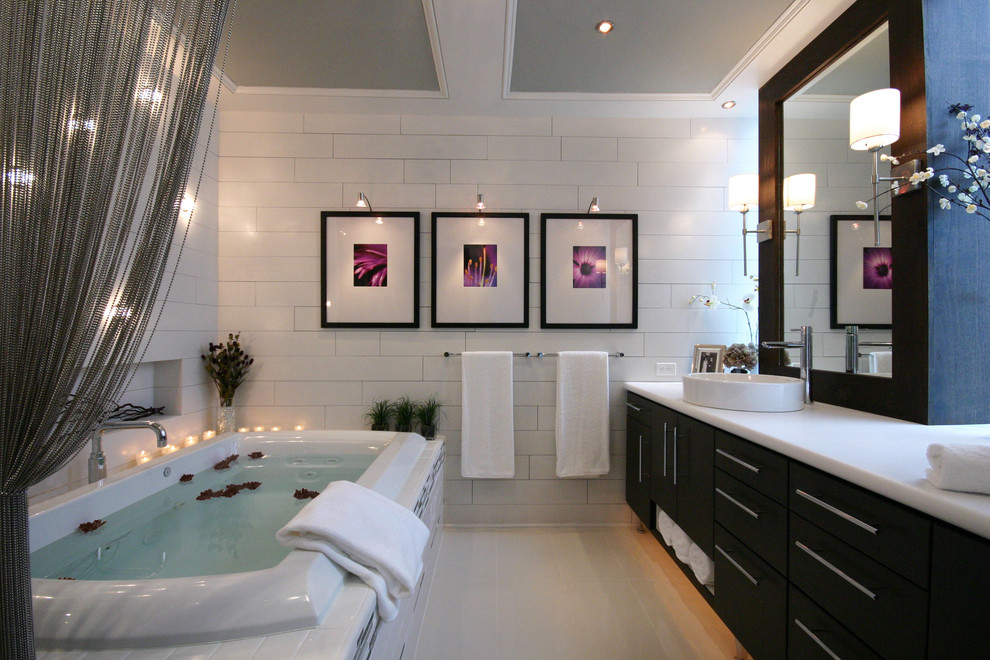 Inspiration for a mid-sized contemporary master bathroom in Charlotte with a drop-in tub, subway tile, flat-panel cabinets, dark wood cabinets, laminate benchtops, white tile and a vessel sink.