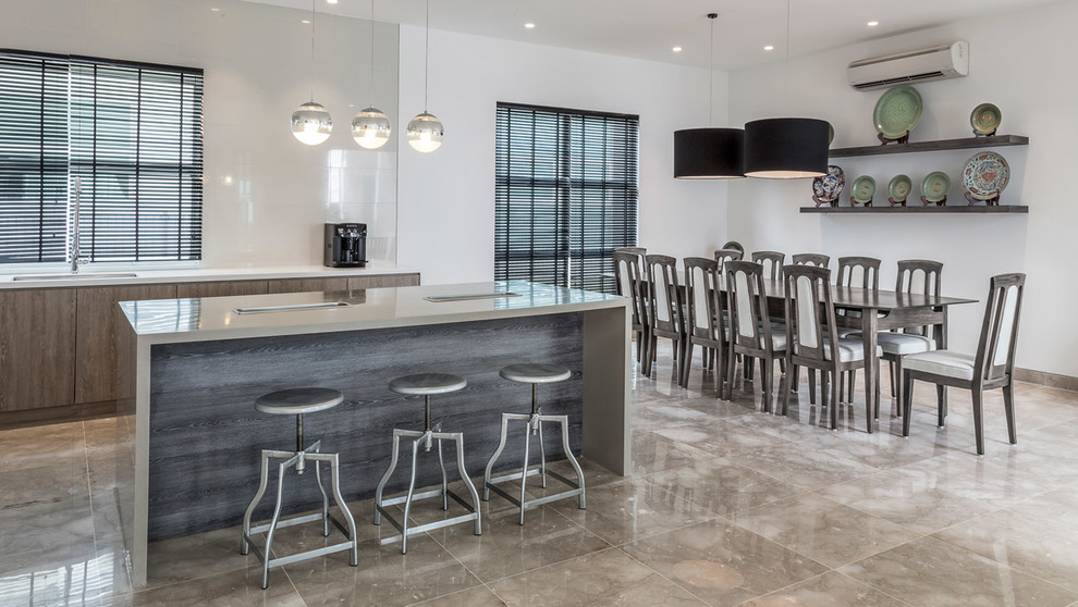 Mid-sized contemporary single-wall eat-in kitchen in Singapore with a single-bowl sink, flat-panel cabinets, light wood cabinets, quartz benchtops, ceramic splashback, stainless steel appliances, marble floors and with island.