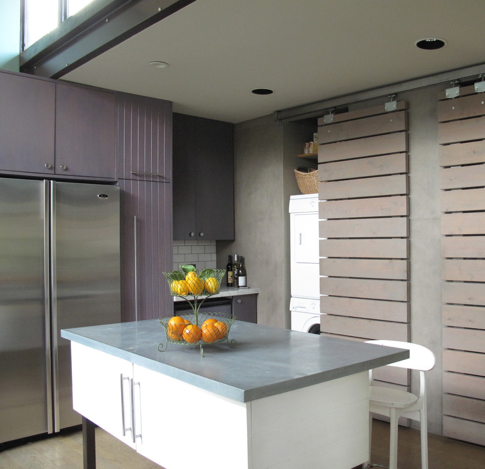 Photo of a large contemporary l-shaped eat-in kitchen in San Francisco with stainless steel appliances, an undermount sink, flat-panel cabinets, white splashback, subway tile splashback, light hardwood floors, with island, purple cabinets and marble benchtops.