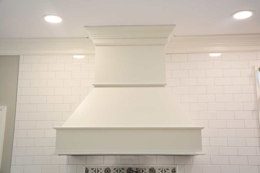 Idéer för att renovera ett stort vit vitt kök, med en rustik diskho, luckor med infälld panel, vita skåp, bänkskiva i kvarts, vitt stänkskydd, rostfria vitvaror, ljust trägolv, en köksö och brunt golv