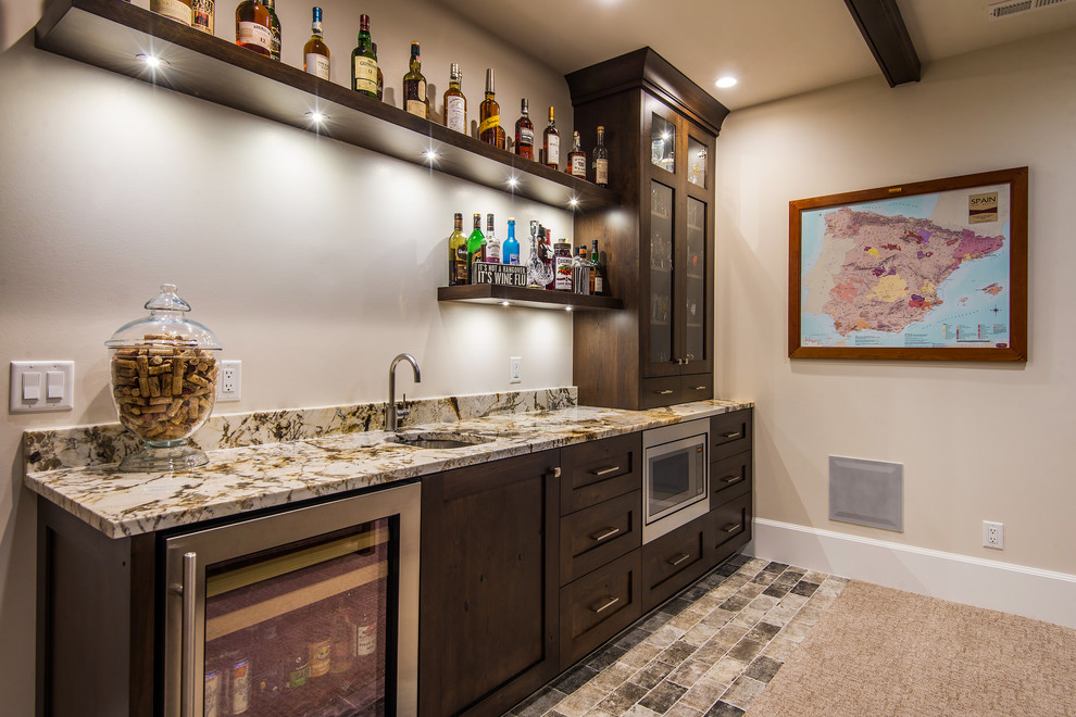 This is an example of a country single-wall wet bar in Salt Lake City with an undermount sink, shaker cabinets and dark wood cabinets.