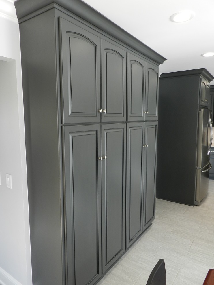Mid-sized transitional l-shaped porcelain tile and beige floor enclosed kitchen photo in Cleveland with an undermount sink, raised-panel cabinets, gray cabinets, granite countertops, white backsplash, subway tile backsplash, stainless steel appliances and an island