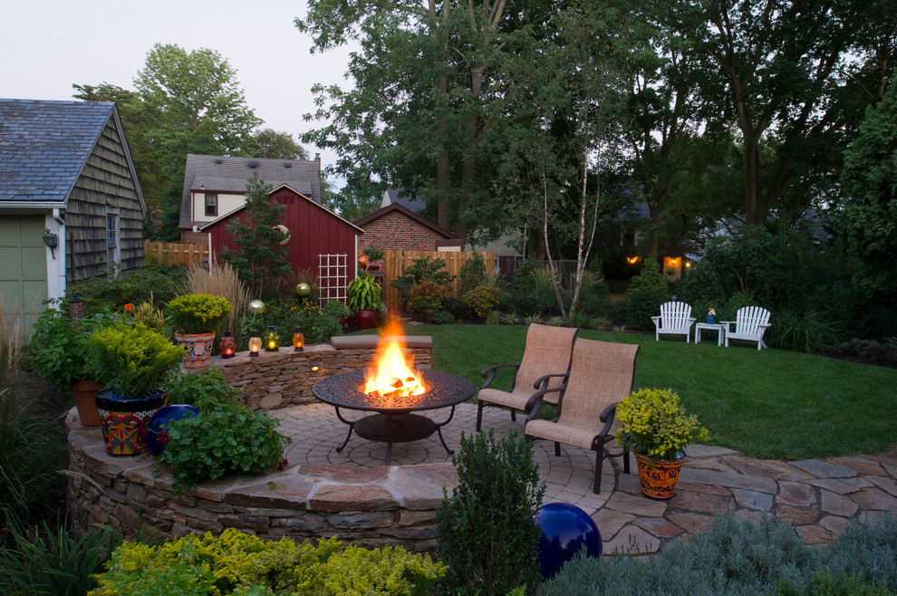 This is an example of a traditional backyard patio in Other with a fire feature.