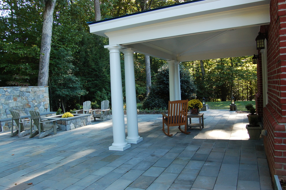 This is an example of a large traditional backyard patio in DC Metro with a fire feature and natural stone pavers.