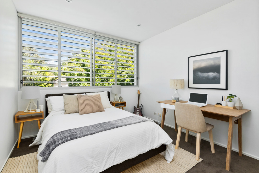 Design ideas for a beach style guest bedroom in Sydney with white walls, carpet and brown floor.