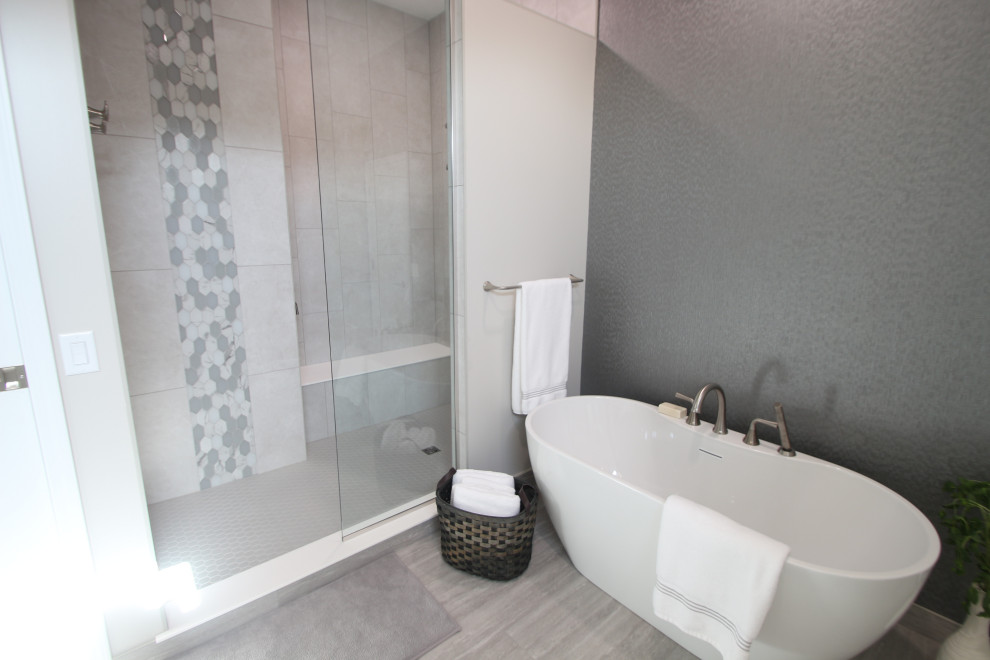 Freestanding bathtub - large transitional master ceramic tile, gray floor, double-sink and wallpaper freestanding bathtub idea with white cabinets, gray walls, an undermount sink, quartz countertops, white countertops and a built-in vanity