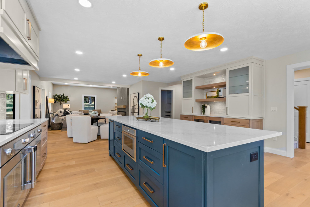 Mid-sized transitional u-shaped open concept kitchen photo with recessed-panel cabinets, white cabinets, stainless steel appliances and an island
