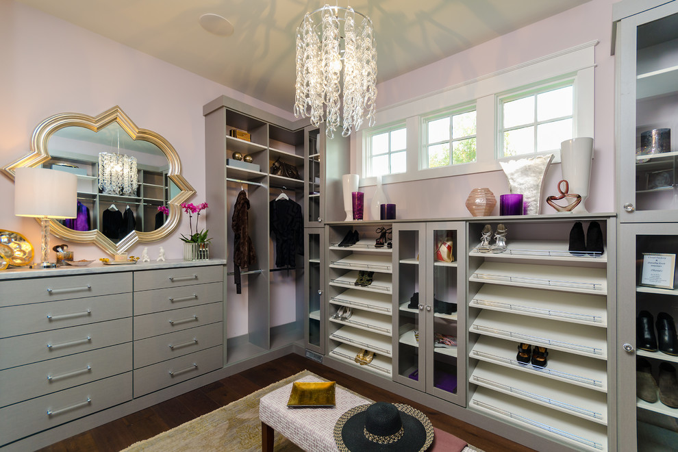 Photo of a mid-sized modern women's walk-in wardrobe in Los Angeles with flat-panel cabinets, grey cabinets and dark hardwood floors.