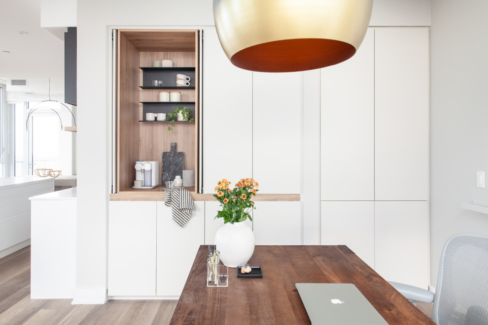 Mittelgroßes Modernes Arbeitszimmer ohne Kamin mit Arbeitsplatz, beiger Wandfarbe, Laminat, freistehendem Schreibtisch und braunem Boden in Toronto