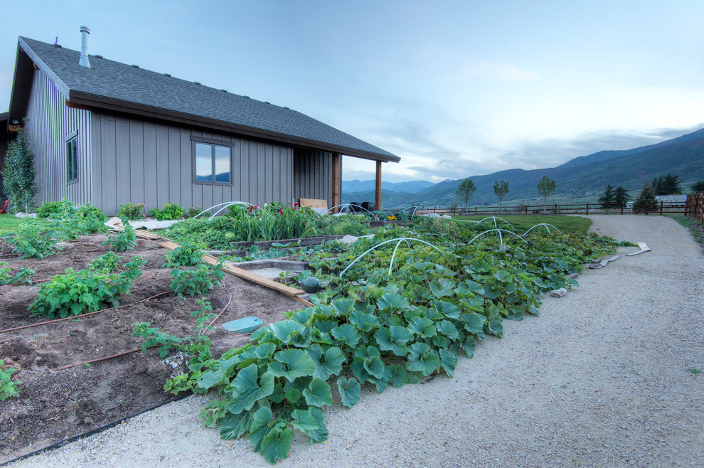 This is an example of a large country side yard partial sun driveway for summer in Salt Lake City with a vegetable garden and gravel.