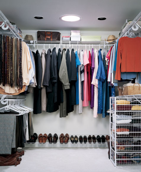Photo of a large modern gender-neutral walk-in wardrobe in Minneapolis with carpet.
