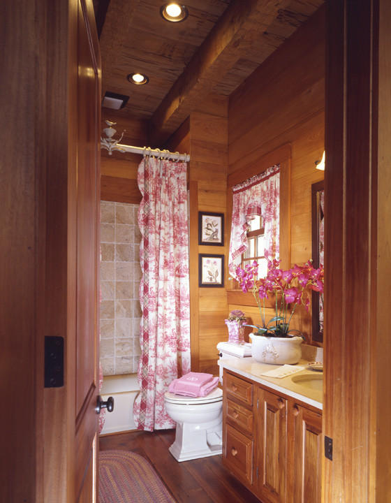 Inspiration for a mid-sized country master bathroom in Atlanta with an undermount sink, raised-panel cabinets, medium wood cabinets, marble benchtops, a shower/bathtub combo, a two-piece toilet, medium hardwood floors, a drop-in tub and multi-coloured walls.