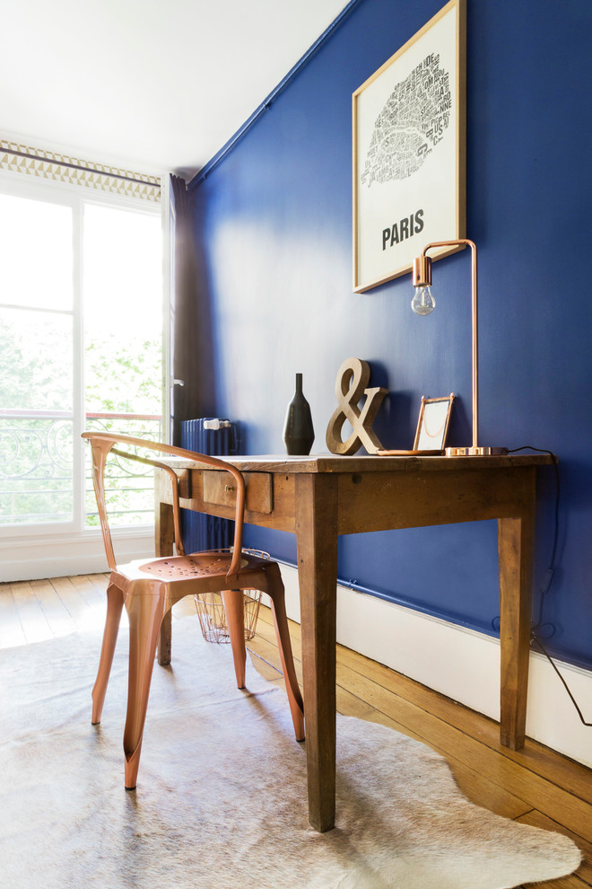 Idée de décoration pour une grande chambre design avec un mur bleu et parquet foncé.