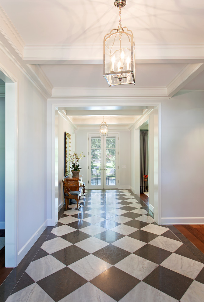 Photo of a large traditional entry hall in Austin with white walls, multi-coloured floor and vinyl floors.