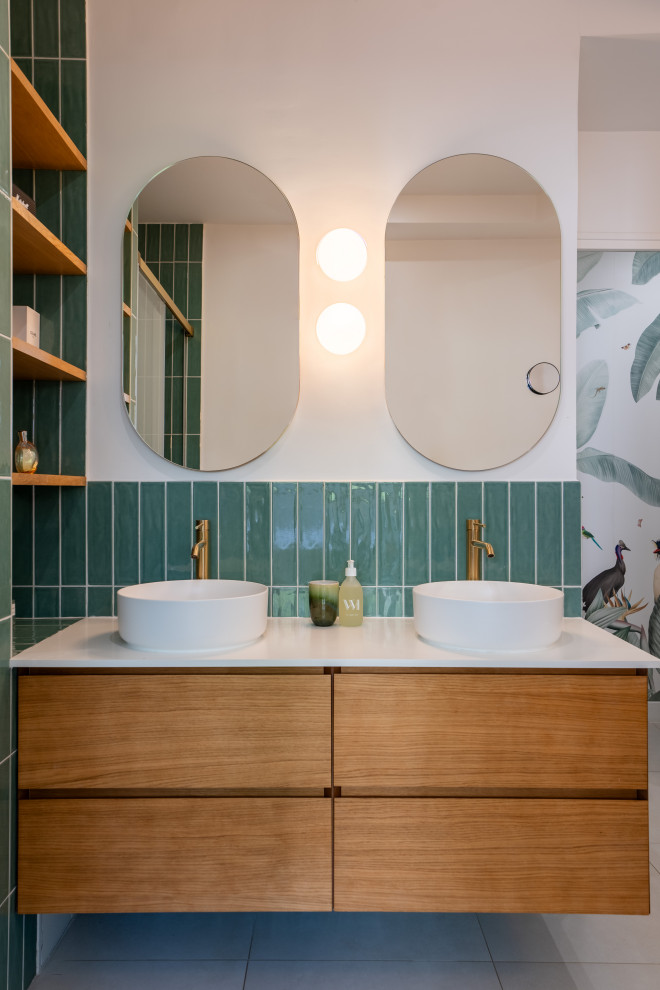 パリにあるラグジュアリーな中くらいなモダンスタイルのおしゃれな浴室 (インセット扉のキャビネット、茶色いキャビネット、アルコーブ型シャワー、緑のタイル、白い壁、セラミックタイルの床、オーバーカウンターシンク、緑の床、開き戸のシャワー、白い洗面カウンター、洗面台2つ、フローティング洗面台、壁紙) の写真