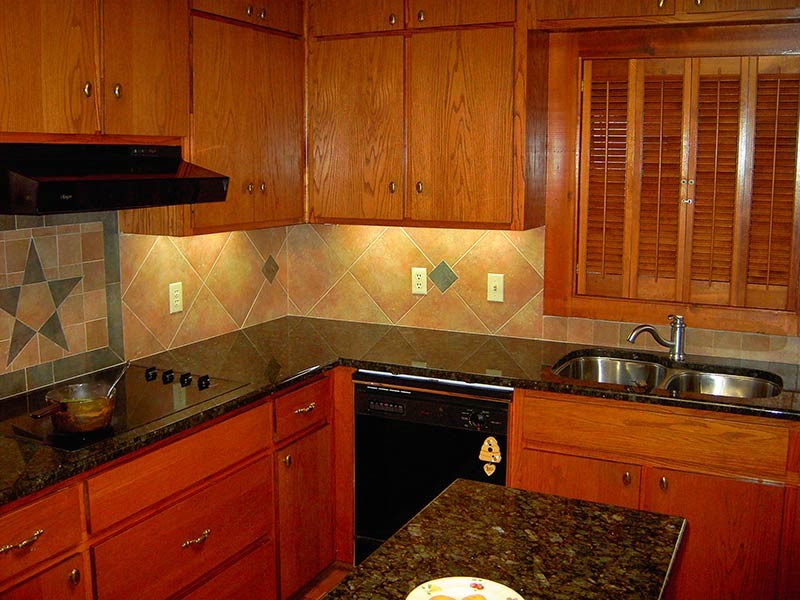 Kitchen - transitional medium tone wood floor kitchen idea in Austin with a double-bowl sink, medium tone wood cabinets, granite countertops, brown backsplash, black appliances and an island