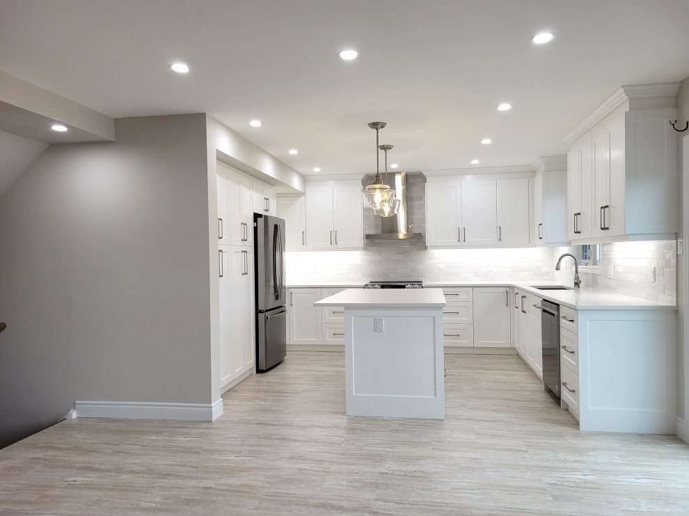 Eat-in kitchen - huge transitional u-shaped vinyl floor and multicolored floor eat-in kitchen idea with an undermount sink, white cabinets, quartzite countertops, gray backsplash, stone tile backsplash, stainless steel appliances, an island and white countertops
