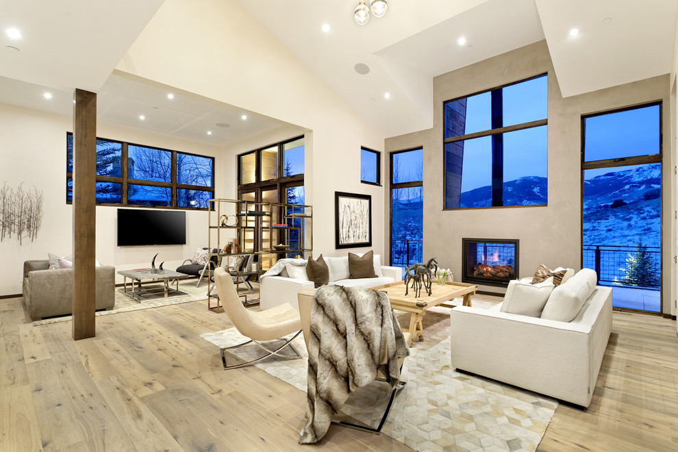 Large contemporary formal open concept living room in Denver with white walls, light hardwood floors, a two-sided fireplace, a concrete fireplace surround, a wall-mounted tv and beige floor.