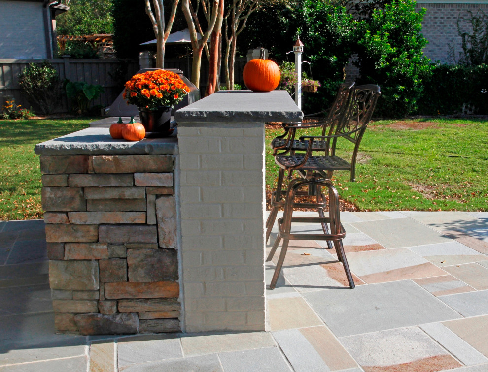 Пример оригинального дизайна: двор на заднем дворе с летней кухней и покрытием из каменной брусчатки