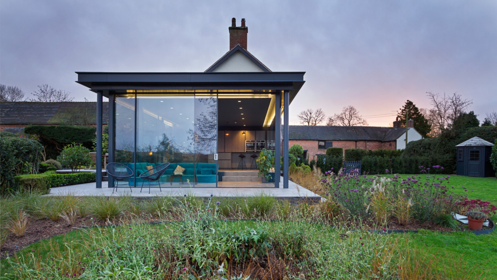 ウエストミッドランズにあるラグジュアリーなコンテンポラリースタイルのおしゃれな家の外観 (ガラスサイディング) の写真
