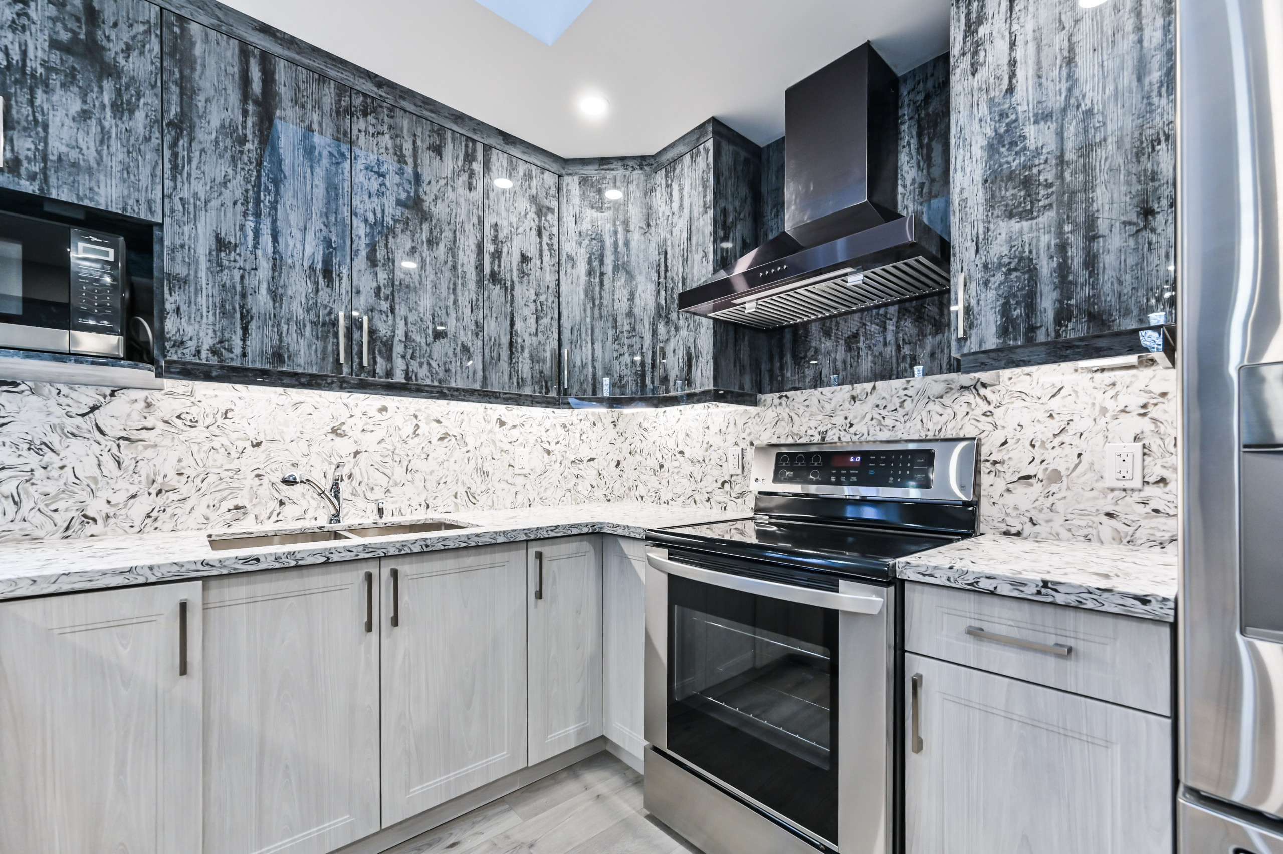 Example of a mid-sized minimalist galley eat-in kitchen design in Toronto with a double-bowl sink, quartzite countertops, black backsplash, stone slab backsplash, stainless steel appliances, an island