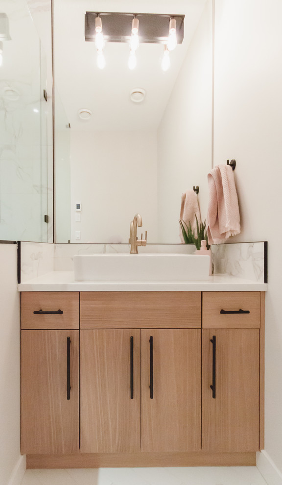 This is an example of a small transitional 3/4 bathroom in Other with flat-panel cabinets, light wood cabinets, a one-piece toilet, white tile, ceramic tile, white walls, ceramic floors, a vessel sink, engineered quartz benchtops, white floor, a hinged shower door and white benchtops.