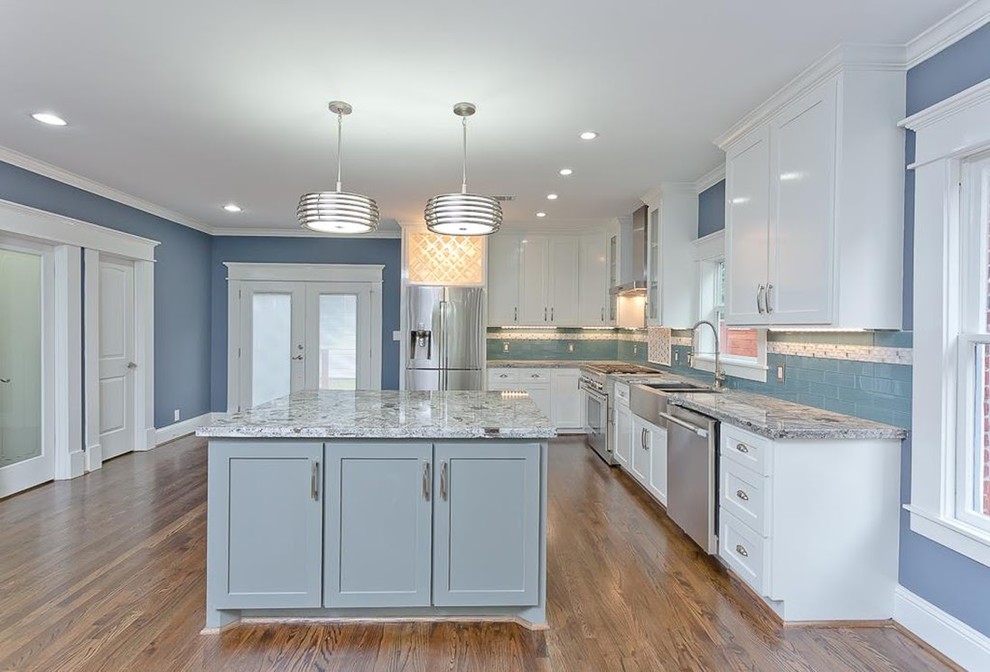 Mid-sized traditional u-shaped open plan kitchen in Houston with a drop-in sink, shaker cabinets, light wood cabinets, marble benchtops, green splashback, mosaic tile splashback, stainless steel appliances, medium hardwood floors and with island.