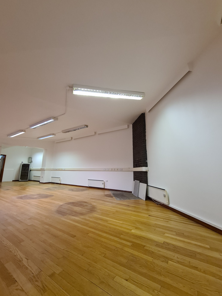 Réalisation d'un grand bureau atelier minimaliste avec un mur blanc, parquet foncé, un sol marron et un plafond décaissé.