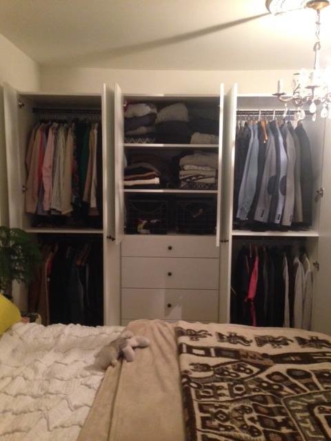 Photo of a mid-sized contemporary gender-neutral storage and wardrobe in Toronto with flat-panel cabinets and white cabinets.