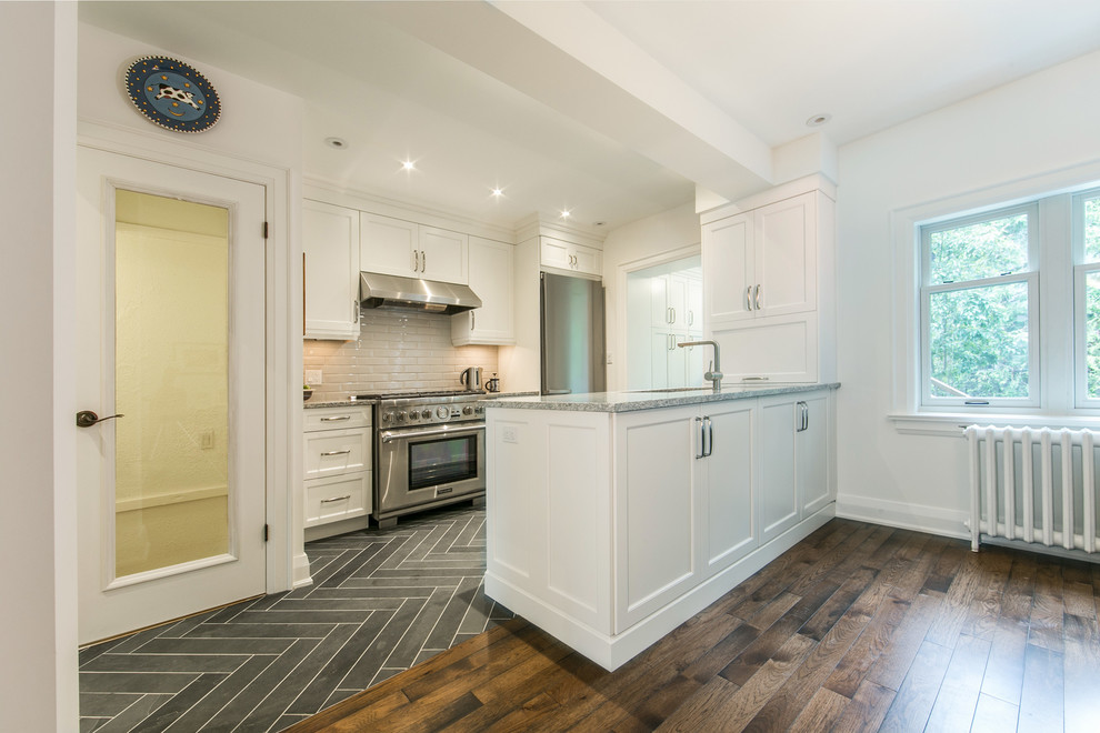 Inspiration for a mid-sized transitional galley slate floor eat-in kitchen remodel in Toronto with shaker cabinets, white cabinets, stainless steel appliances, a peninsula, an undermount sink, quartzite countertops, gray backsplash and ceramic backsplash