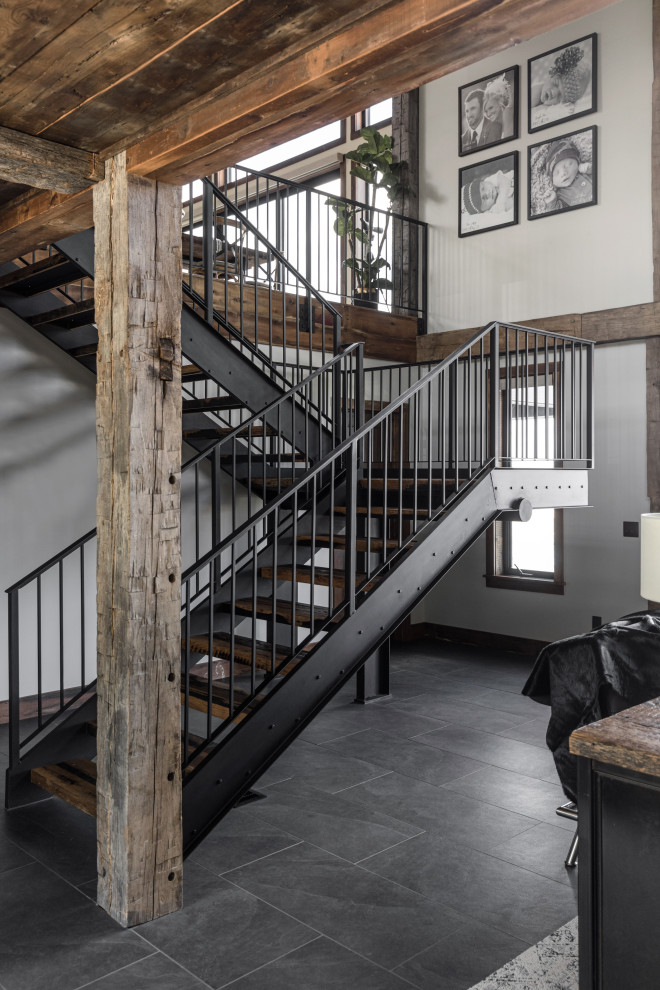 Design ideas for a country wood l-shaped staircase with open risers, metal railing and wood walls.
