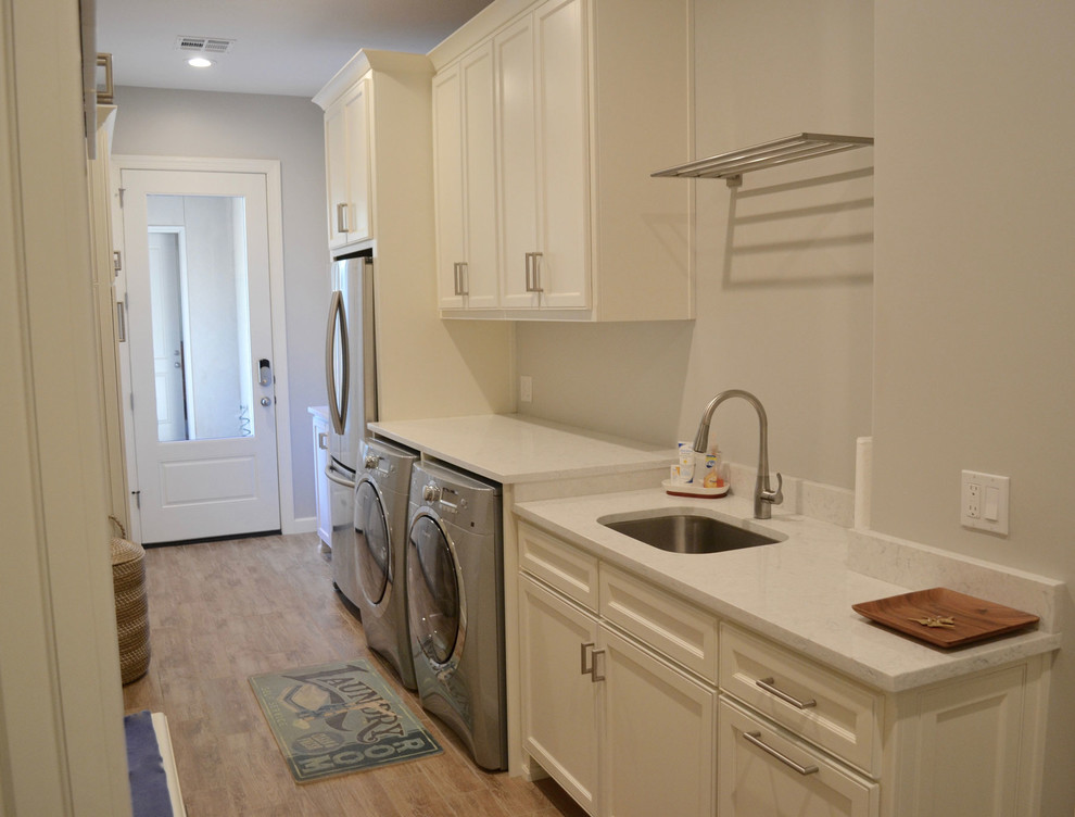 Design ideas for a galley utility room in Other with white cabinets and a side-by-side washer and dryer.