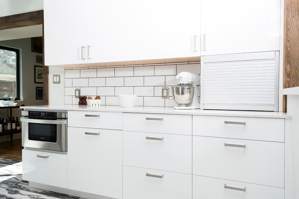 Mid-sized contemporary l-shaped separate kitchen in Dallas with flat-panel cabinets, white splashback, stainless steel appliances, an undermount sink, white cabinets, quartzite benchtops, subway tile splashback, porcelain floors and with island.