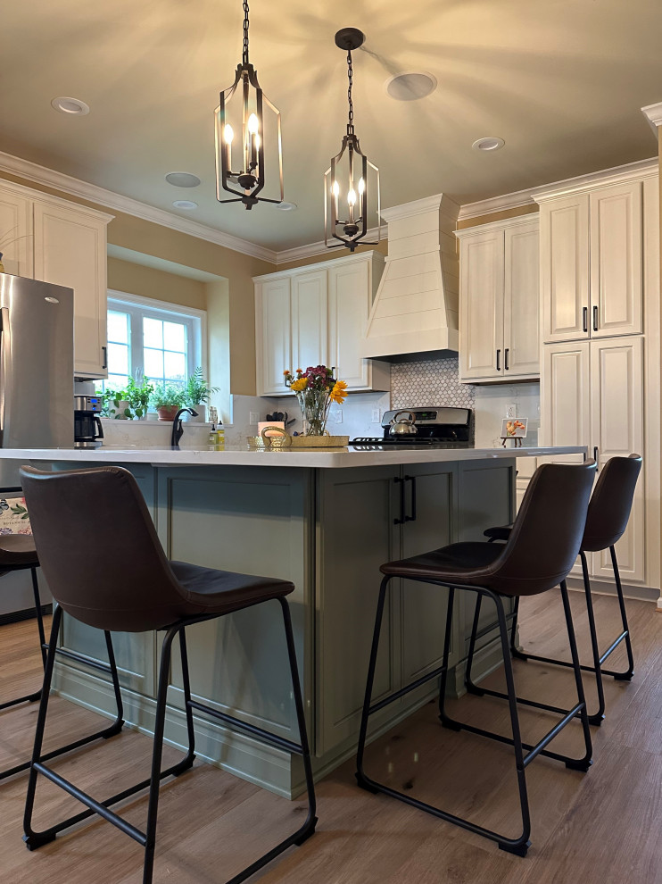 Mid-sized elegant l-shaped vinyl floor and beige floor eat-in kitchen photo with an undermount sink, raised-panel cabinets, white cabinets, quartz countertops, beige backsplash, quartz backsplash, stainless steel appliances, an island and beige countertops