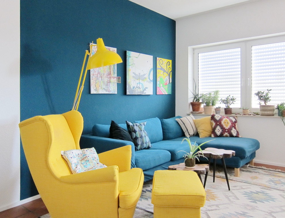 Kleines, Offenes Modernes Wohnzimmer mit blauer Wandfarbe, Keramikboden und braunem Boden in Köln