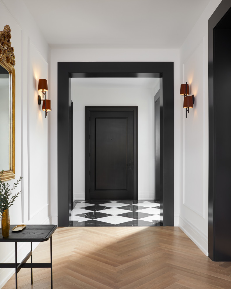 This is an example of a small contemporary foyer in Toronto with white walls, porcelain flooring, a single front door, a black front door and white floors.