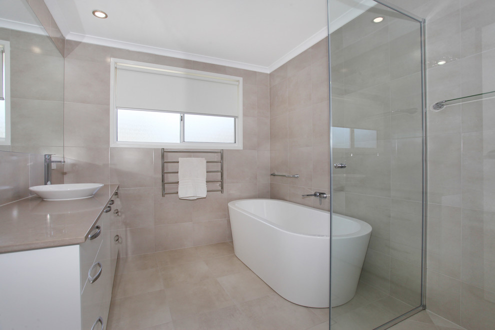 Photo of a mid-sized contemporary bathroom in Sunshine Coast with white cabinets, a freestanding tub, a corner shower, beige tile, porcelain tile, beige walls, porcelain floors, a vessel sink and engineered quartz benchtops.
