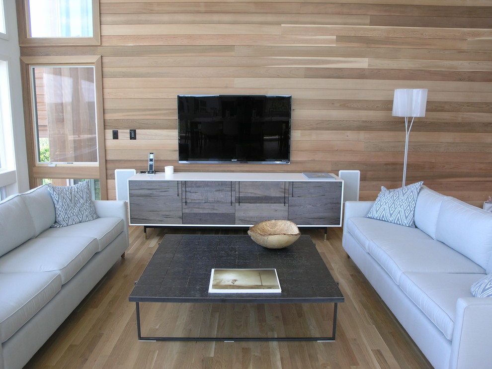 This is an example of a large contemporary open concept living room in New York with brown walls, light hardwood floors, a standard fireplace, a stone fireplace surround and a wall-mounted tv.