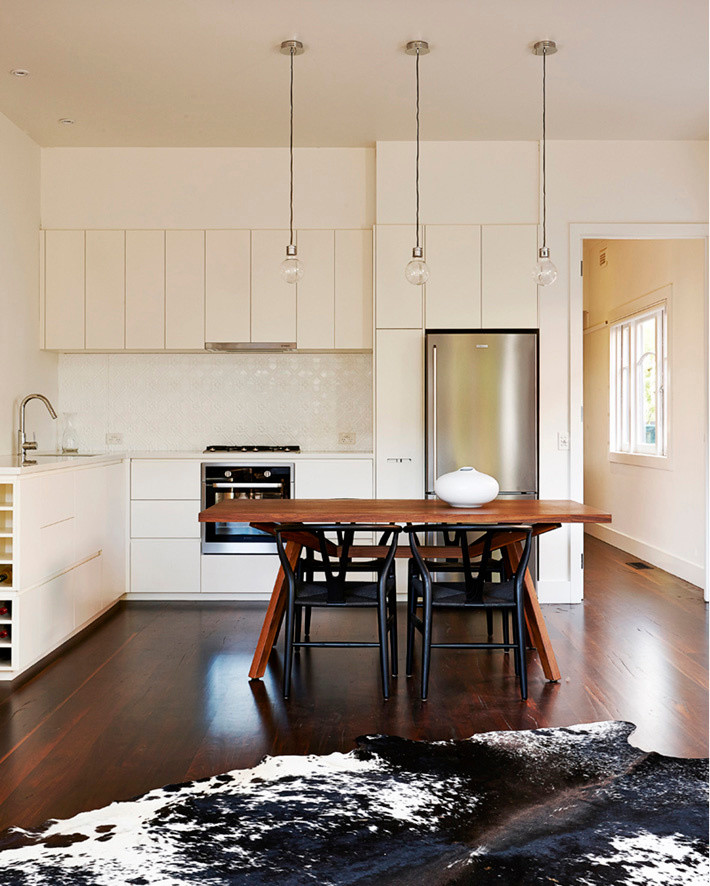 Inspiration for a small contemporary l-shaped eat-in kitchen in Melbourne with an undermount sink, flat-panel cabinets, white cabinets, quartz benchtops, white splashback, metal splashback, stainless steel appliances and medium hardwood floors.