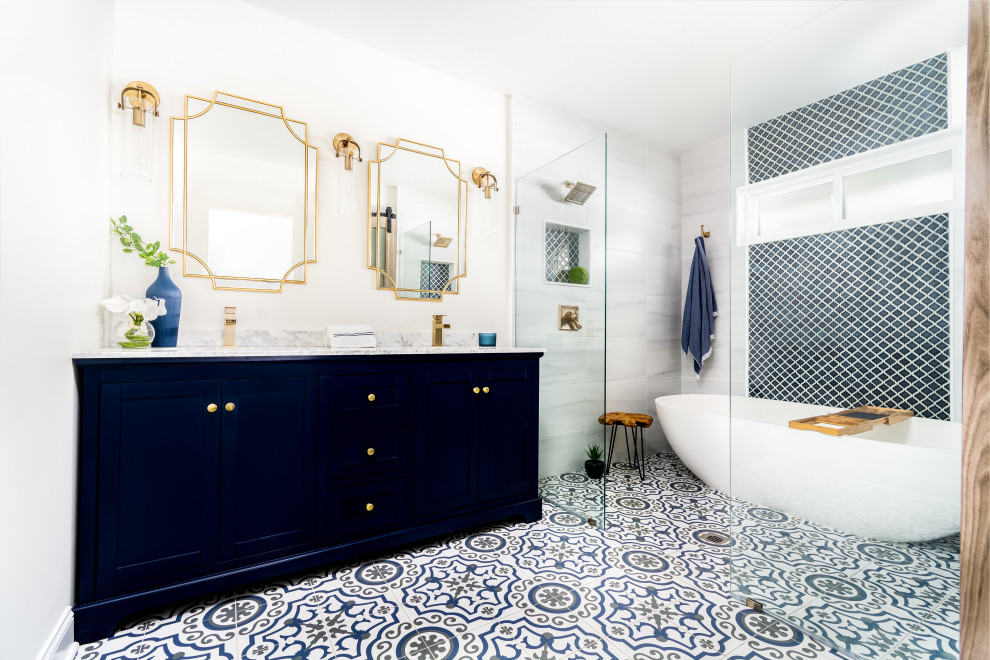 ニューヨークにある高級な中くらいなトランジショナルスタイルのおしゃれなマスターバスルーム (シェーカースタイル扉のキャビネット、青いキャビネット、置き型浴槽、洗い場付きシャワー、分離型トイレ、グレーのタイル、セラミックタイル、白い壁、セラミックタイルの床、アンダーカウンター洗面器、大理石の洗面台、青い床、オープンシャワー、黄色い洗面カウンター、トイレ室、洗面台2つ、独立型洗面台) の写真