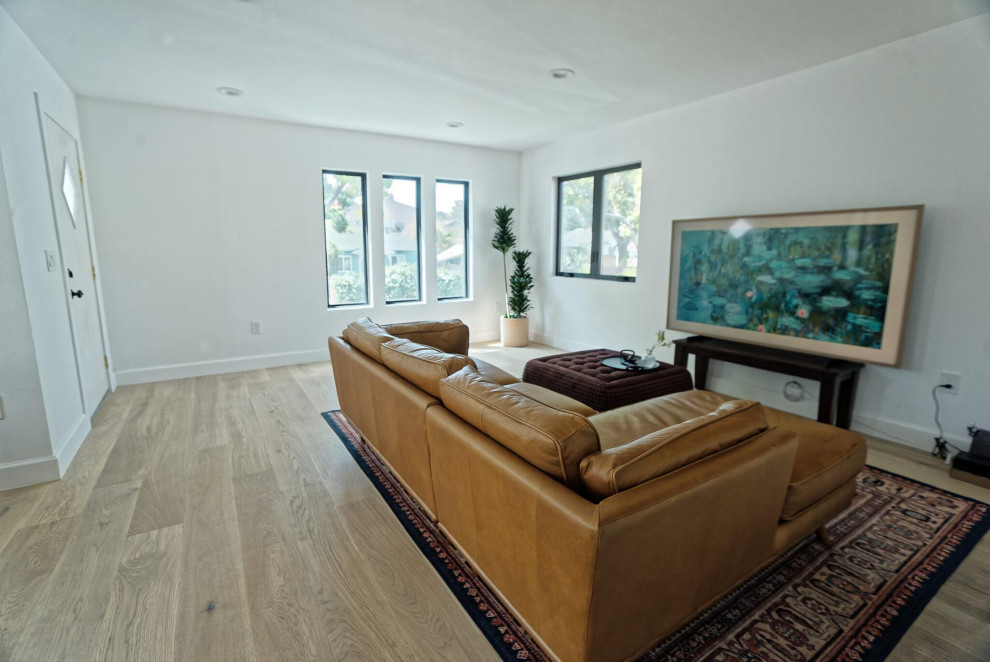 Idée de décoration pour un grand salon nordique ouvert avec un mur blanc et sol en stratifié.