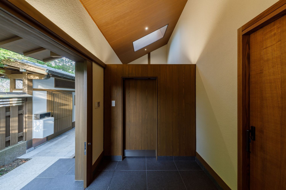大阪にある高級な広いアジアンスタイルのおしゃれな玄関 (白い壁、セラミックタイルの床、茶色いドア、グレーの床、板張り天井) の写真